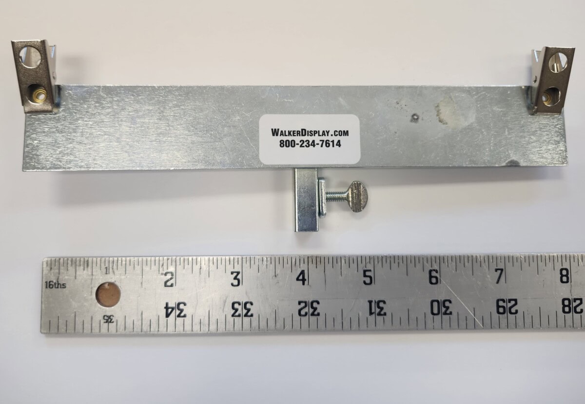 a metal bracket with adjustable knob and mounting holes is placed above a ruler showing inches; a label reads "walkerdisplay.com 800 234 7614.